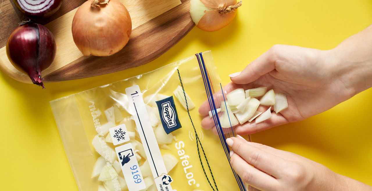 Kleingeschnittene Zwiebeln werden von Hand in einen Toppits SafeLoc Beutel zum Einfrieren gefüllt. 